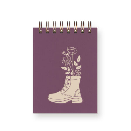 Purple spiral bound mini notebook featuring a hand drawn image of a hiking boot with flowers inside